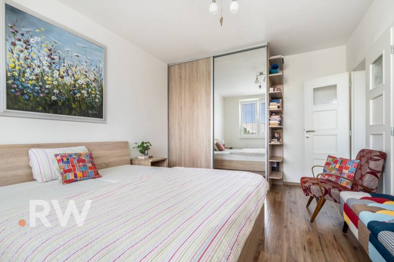 REWIN I Priestranný 3 izbový byt v tichej lokalite Senca - Spálňa v 3-izbovom byte s veľkou posteľou, šatníkom a farebným kreslom.