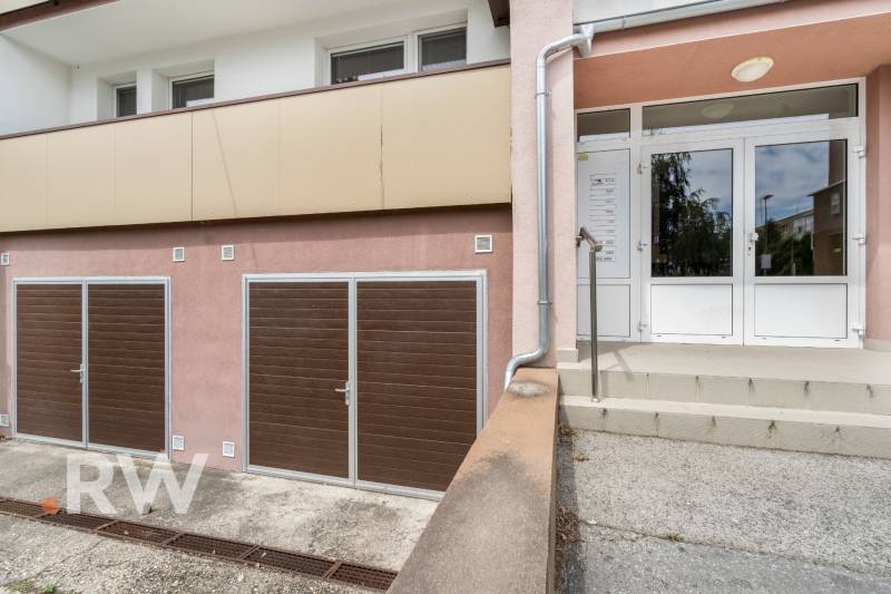 REWIN I Priestranný 3 izbový byt v tichej lokalite Senca - Vchodový priestor bytového domu na Kysuckej ulici v Senci s garážovými dverami.