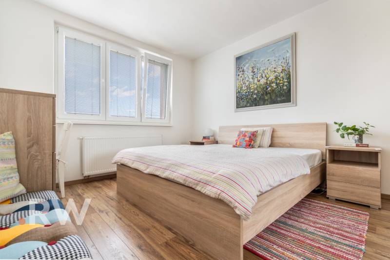 REWIN I Priestranný 3 izbový byt v tichej lokalite Senca - Spálňa v 3-izbovom byte so svetlou posteľou a obrazom na stene.