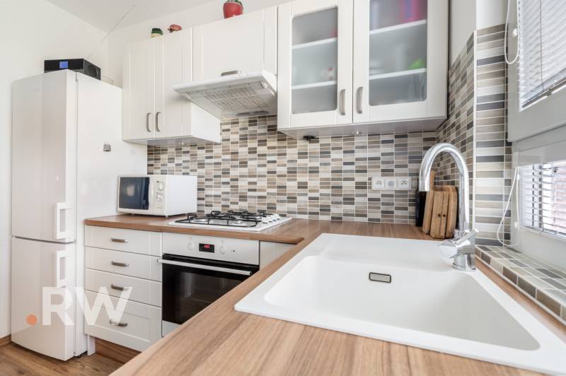 REWIN I Priestranný 3 izbový byt v tichej lokalite Senca - Kuchyňa v 3-izbovom byte s modernými spotrebičmi a drevenou pracovnou doskou.