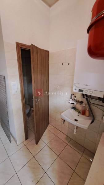 PRENÁJOM: Obchodný priestor 158m2 - Mostová ulica, Ružomberok - Kúpeľňa v obchodných priestoroch s umývadlom, bojlerom a dverami na toaletu.