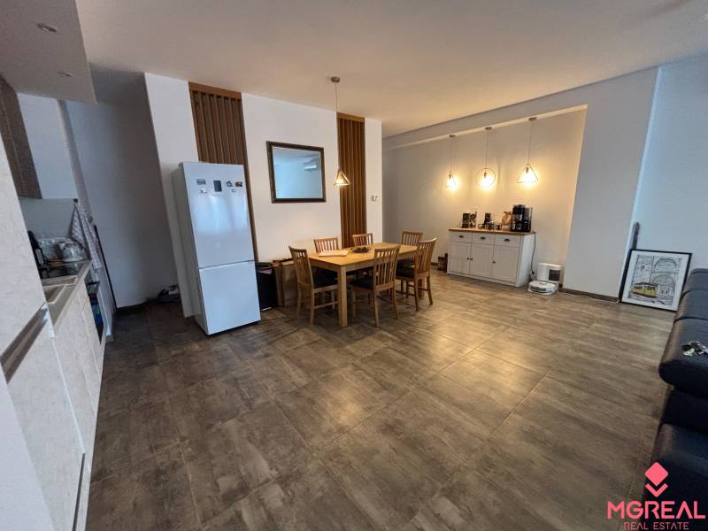 Veľký 96 m2  2 izbový byt s garážovým státím Topoľčany Centrum  - Jedálenský kút v 2-izbovom byte so stolom a stoličkami, podlaha s dreveným dekorom.