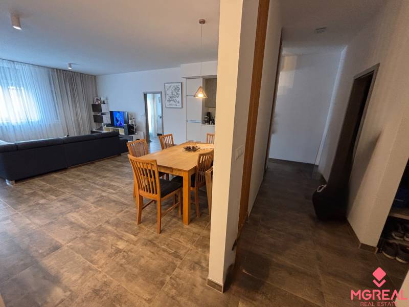 Veľký 96 m2  2 izbový byt s garážovým státím Topoľčany Centrum  - Jedálenský stôl s drevenými stoličkami v 2-izbovom byte. Súčasťou je pohovka a televízor.