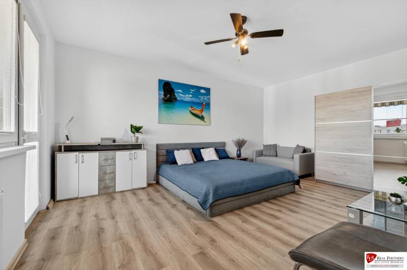 REZERVOVANÉ Predaj moderný 1-izbový byt, 45,24m2, Bratislava IV - 1-izbový byt s podlahou s dreveným dekorom, posteľou, skriňou a sedačkou.