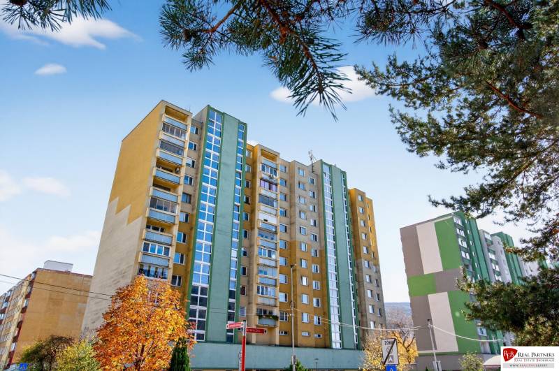 REZERVOVANÉ Predaj moderný 1-izbový byt, 45,24m2, Bratislava IV - Bytový dom na ulici Milana Marečka v Bratislave, Devínskej Novej Vsi so stromami v popredí.