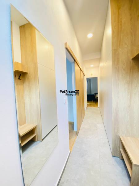 NA PRENÁJOM ŠTÝLOVÝ 2-IZBOVÝ BYT V CENTRE KOŠÍC, DREVNÝ TRH - Chodba s podlahou s dreveným dekorom v 2-izbovom byte, skriňami a zrkadlom.