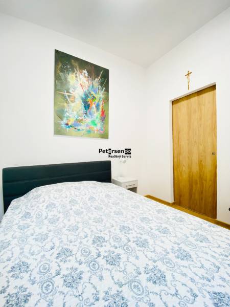 NA PRENÁJOM ŠTÝLOVÝ 2-IZBOVÝ BYT V CENTRE KOŠÍC, DREVNÝ TRH - Spálňa s obrazom na stene, posteľou a nočným stolíkom v 2-izbovom byte.