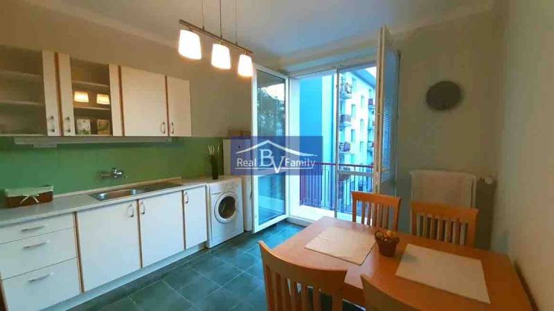 PRENAJATÉ - PRENÁJOM, KOŠICKÁ, RUŽINOV - 2 IZBOVÝ BYT - Kuchyňa v 2-izbovom byte s bielymi skrinkami, jedálenským stolom a balkónom.