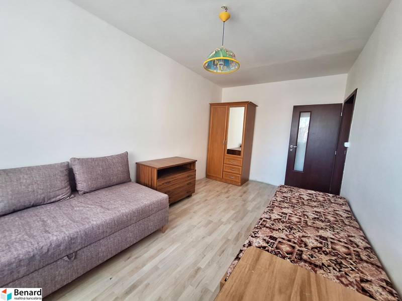 REZERVOVANÝ 2,5 IZBOVÝ BYT, 65 M2,PREŠOV,UL. FEDERÁTOV - Obývacia izba v 3-izbovom byte s podlahou s dreveným dekorom a jednoduchým nábytkom.