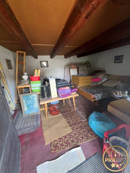 !! NOVÁ CENA !! predaj romantickej chalúpky v Šípkove  - Interiér nepoužívanej chaty s vidieckym nábytkom a stropnými trámami.