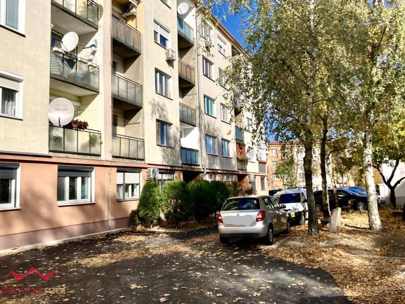 3-izbový byt s loggiou v širšom centre, Komárno - Bytový dom na Mederčskej v Komárne so zaparkovanými autami a stromami.