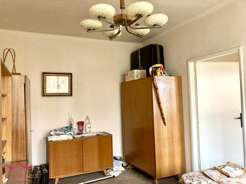 3-izbový byt s loggiou v širšom centre, Komárno - Izba v 3-izbovom byte s dreveným nábytkom a dekoratívnym lustrom.