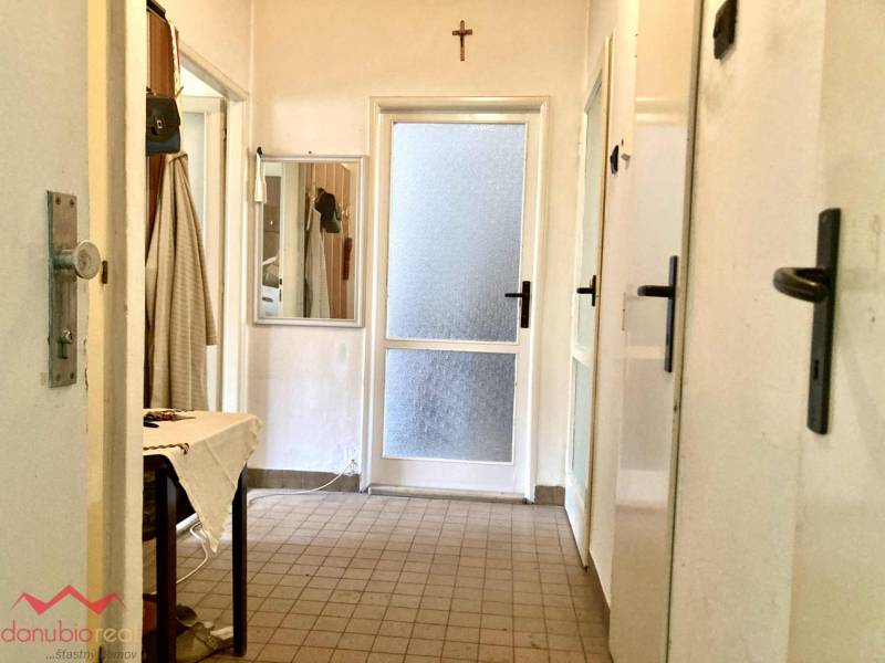 3-izbový byt s loggiou v širšom centre, Komárno - Chodba v 3-izbovom byte s dlažbou, zrkadlom a pláteným stolom.