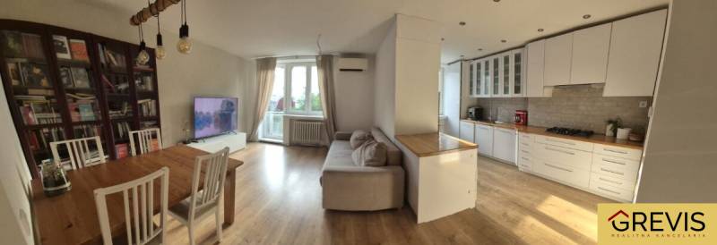 Elegantný 3 izbový byt (78 m²) s 2 balkónmi po kompletnej rekonštrukci - Priestranná kuchyňa s obývačkou v 3-izbovom byte. Podlaha s dreveným dekorom, svetlý nábytok.