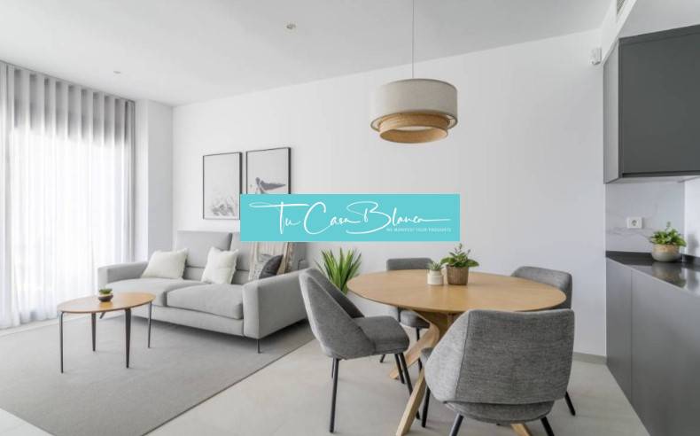 Novostavba Apartmán La Mata, 78m2, bazén, garáž - Svetlá obývacia izba Rekreačného apartmánu so sivým kreslom a dreveným stolom.