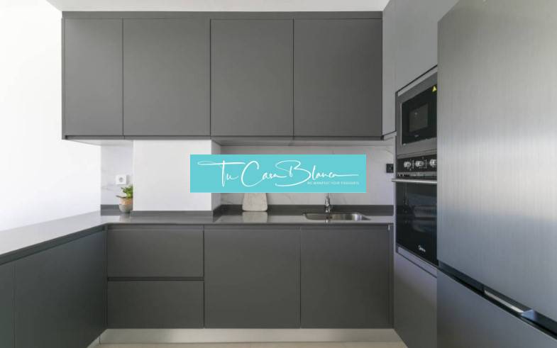 Novostavba Apartmán La Mata, 78m2, bazén, garáž - Kuchyňa v Rekreačnom apartmáne s tmavými skrinkami a zabudovanými spotrebičmi.