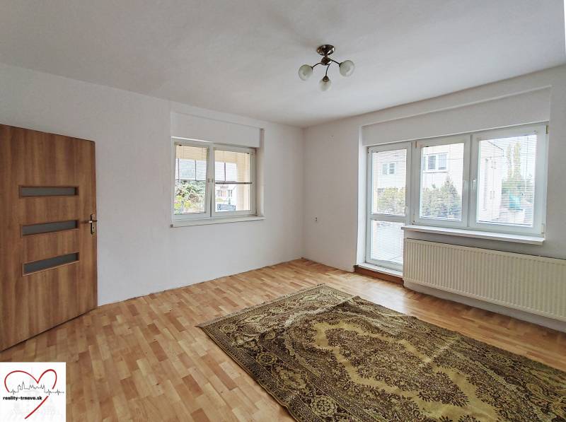 Predaj rodinného domu, Topoľová, Topoľová, Galanta - Izba v rodinnom dome s podlahou s dreveným dekorom, kobercom a veľkým oknom.