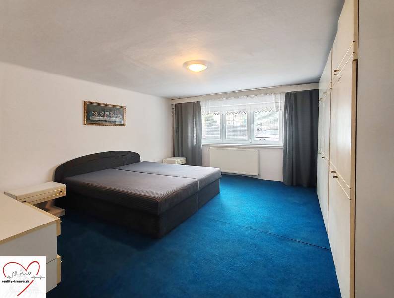 Predaj rodinného domu, Topoľová, Topoľová, Galanta - Spálňa v rodinnom dome s veľkou posteľou, modrým kobercom a vstavanou skriňou.
