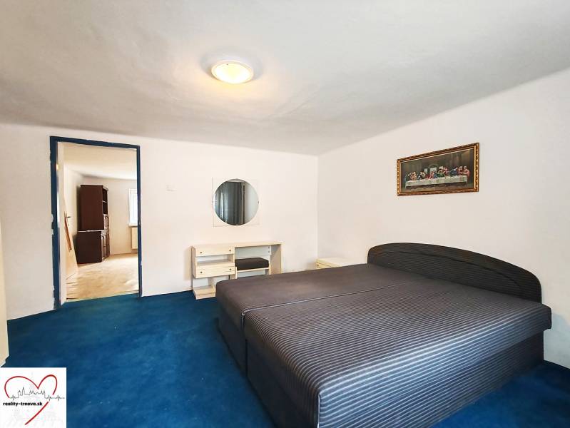 Predaj rodinného domu, Topoľová, Topoľová, Galanta - Spálňa v rodinnom dome s veľkou posteľou, modrý koberec a obraz na stene.