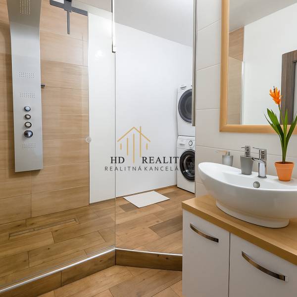 HD reality, predaj 3 izbového bytu na Medvedzí v meste Tvrdošín. - Kúpeľňa v 3-izbovom byte s umývadlom, sprchovým kútom a práčkou, s podlahou s dreveným dekorom.