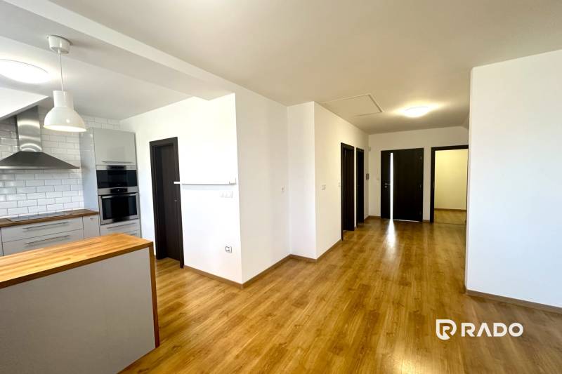 RADO| Podnikajte a zároveň bývajte pod jednou strechou! - Kuchyňa v rodinnom dome s podlahou s dreveným dekorom a bielymi stenami.