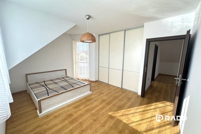 RADO| Podnikajte a zároveň bývajte pod jednou strechou! - Spálňa v rodinnom dome s posteľou, vstavanou skriňou a podlahou s dreveným dekorom.
