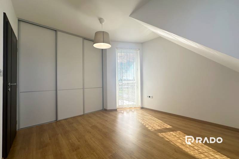 RADO| Podnikajte a zároveň bývajte pod jednou strechou! - Interiér budovy s podlahou s dreveným dekorom, vstavanou skriňou a oknom s roletou.