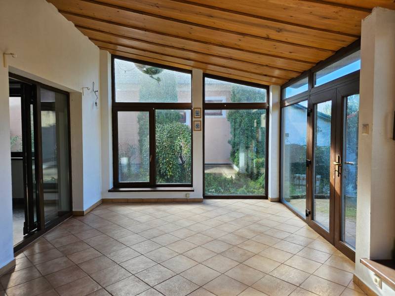 REZERVOVANÉ! Predáme 5-izbový rodinný dom na Štúrovej ulici, Vráble - Izba v rodinnom dome s veľkými oknami a dlažbou, výhľad do záhrady.