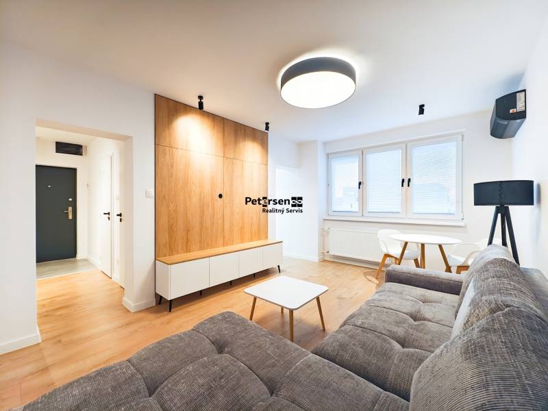 Prenájom úplne nového 2 izb. bytu - skvelá poloha a komfortné bývanie. - Obývacia izba s pohovkou, jedálenským stolom, dreveným dekorom podlahy v 2-izbovom byte.