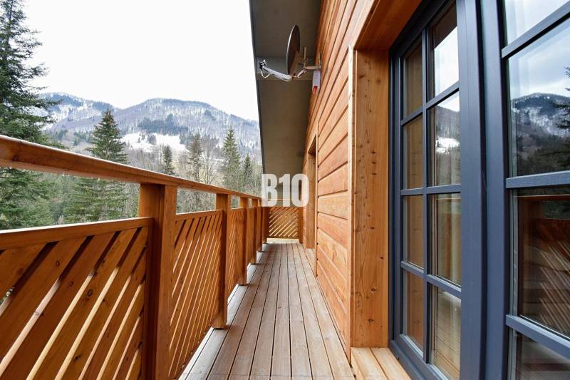 LUKRATÍVNA CHATA - NOVOSTAVBA - SRDCE VRÁTNEJ DOLINY - Balkón chaty v Terchovej s výhľadom na zasnežené hory a lesy.