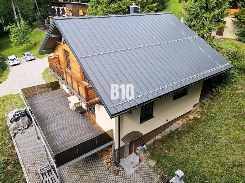 LUKRATÍVNA CHATA - NOVOSTAVBA - SRDCE VRÁTNEJ DOLINY - Chata v Terchovej so šikmou strechou, veľkou terasou a drevenými detailmi.