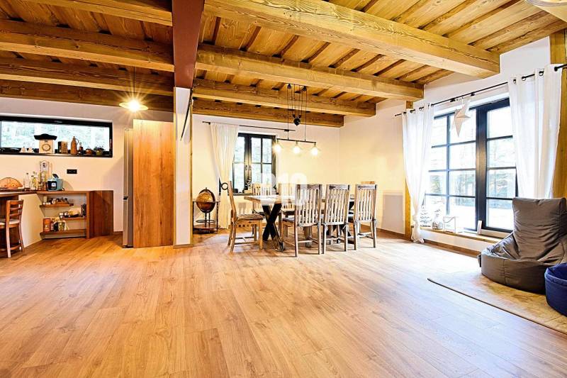 LUKRATÍVNA CHATA - NOVOSTAVBA - SRDCE VRÁTNEJ DOLINY - Otvorený interiér v Chate s podlahou s dreveným dekorom a jedálenským stolom.