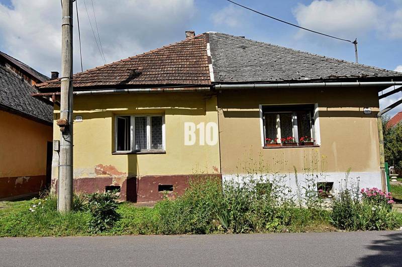 Rodinný dom s veľkým pozemkom o výmere 3271m2  na predaj - Žltý rodinný dom v Partizánskej Ľupči so šikmou strechou a priľahlou záhradou.