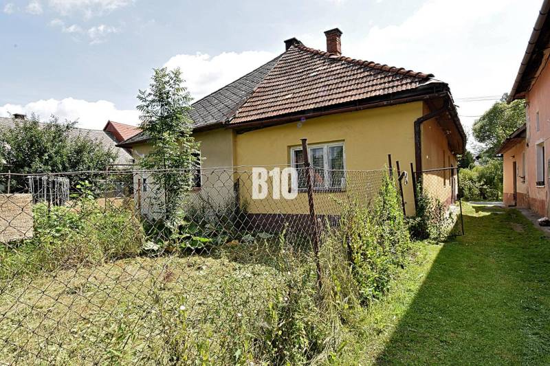 Rodinný dom s veľkým pozemkom o výmere 3271m2  na predaj - Rodinný dom v Partizánskej Ľupči s oplotenou záhradou a vyblednutou fasádou.