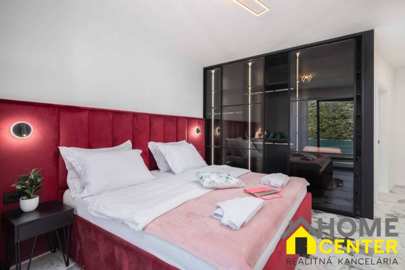 NA PREDAJ novo postavená VILA  /200 m2/ pri mori, Rogoznica - Spálňa vo Vile s posteľou čalúnenou červeným zamatom a sklenenou skriňou.