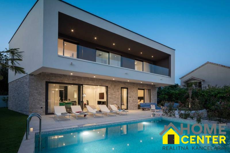 NA PREDAJ novo postavená VILA  /200 m2/ pri mori, Rogoznica - Vila v Bale s bazénom, ležadlami a terasou počas súmraku.