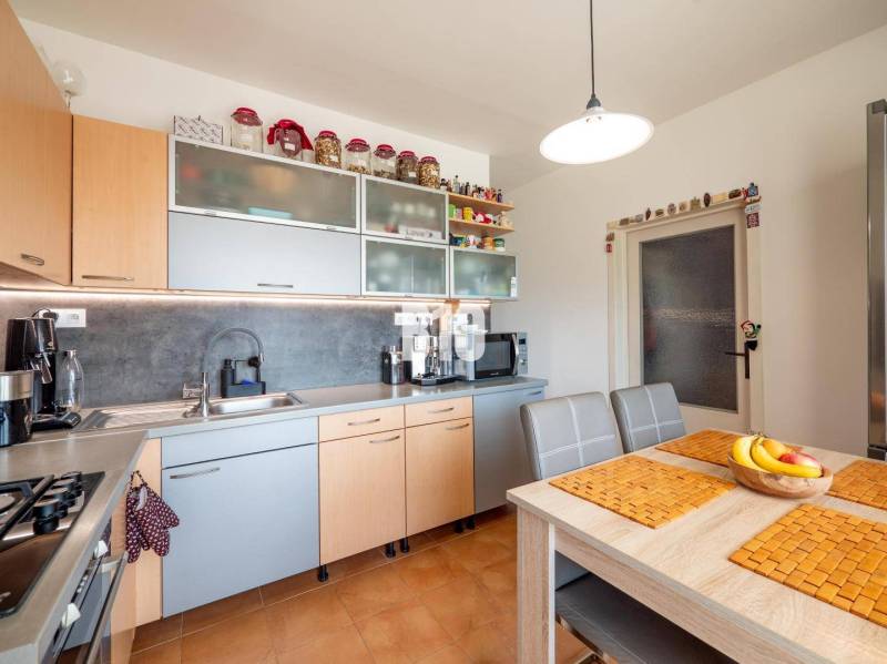 Príjemný 4 izbový byt s balkónom - Klokočina - Kuchyňa v 4-izbovom byte s počítačom a kuchynskou linkou v drevenom dekore.