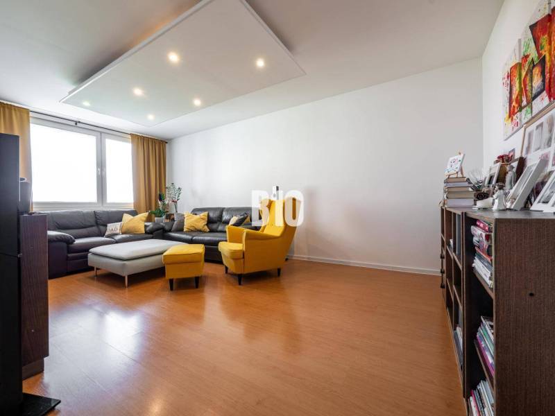 Príjemný 4 izbový byt s balkónom - Klokočina - Obývacia izba v 4-izbovom byte s podlahou s dreveným dekorom a pohodlným nábytkom.