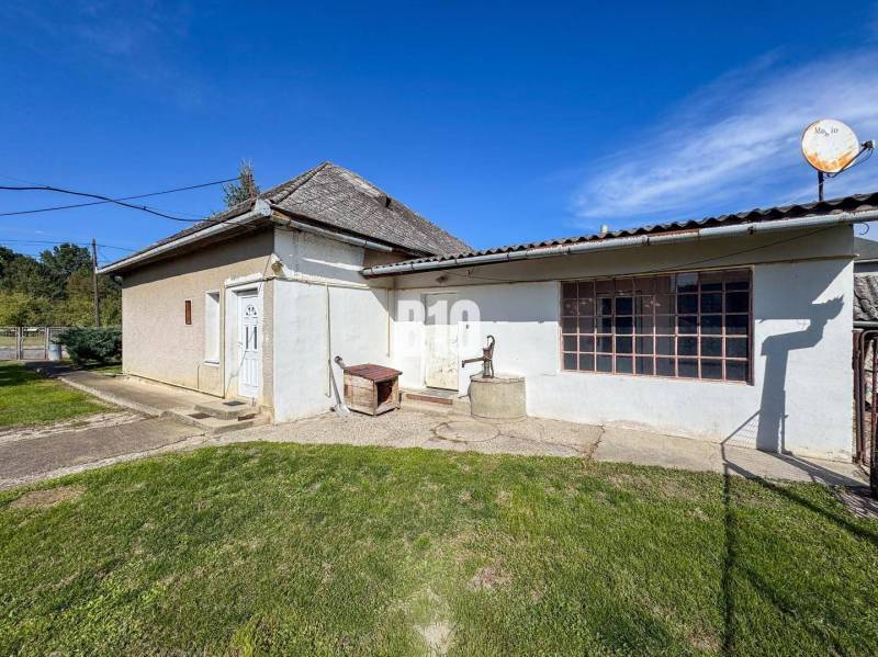 Rodinný dom s veľkým pozemkom (4641 m2)  - Ondrejovce - Rodinný dom v Ondrejovciach, staršia stavba s drevenými oknami a satelitom na streche.