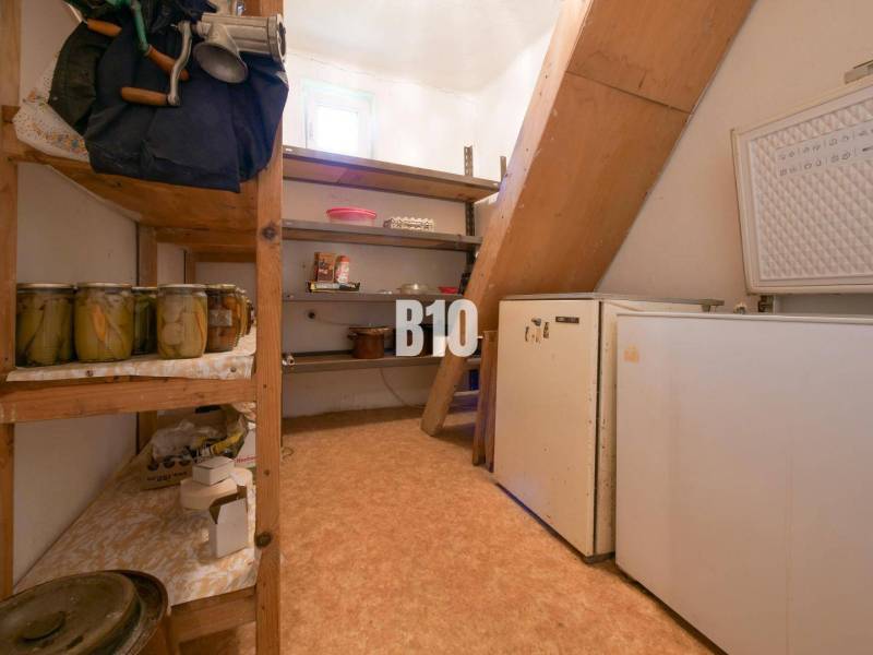 Rodinný dom s krásnym veľkým pozemkom ( stavebným) - Nové Sady - Špajza v rodinnom dome s policami, konzervami a staršou chladničkou.