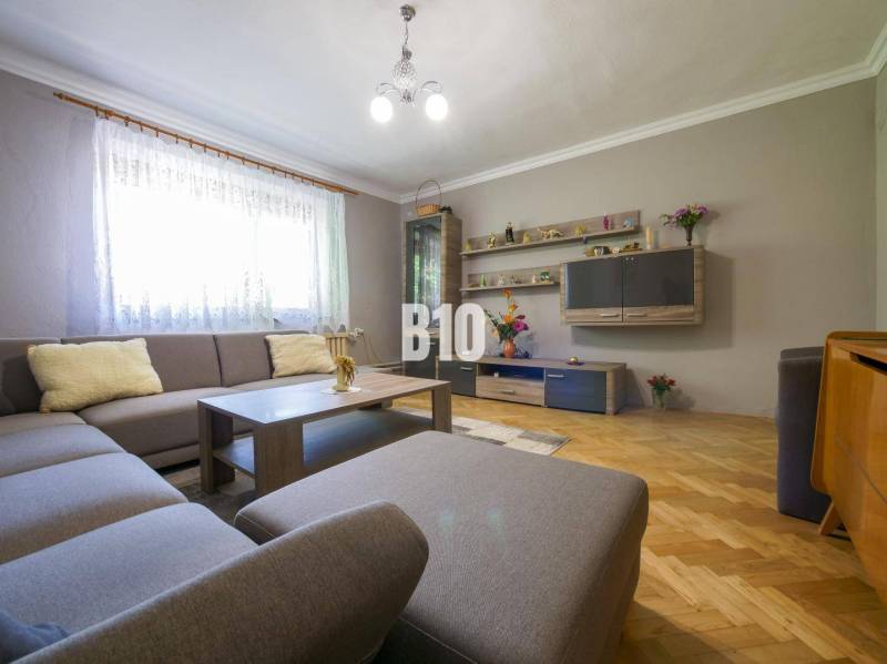 Rodinný dom s krásnym veľkým pozemkom ( stavebným) - Nové Sady - Obývačka s rohovou sedačkou, drevené parkety, dekoratívne police a osvetlenie v rodinnom dome.