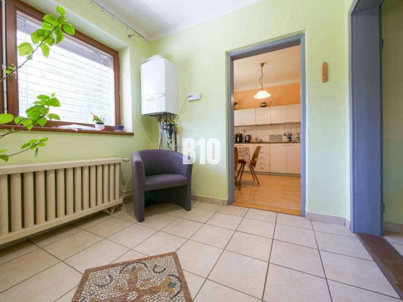 Rodinný dom s krásnym veľkým pozemkom ( stavebným) - Nové Sady - Interiér rodinného domu s predsieňou, rastlinou, kreslom a výhľadom do kuchyne.