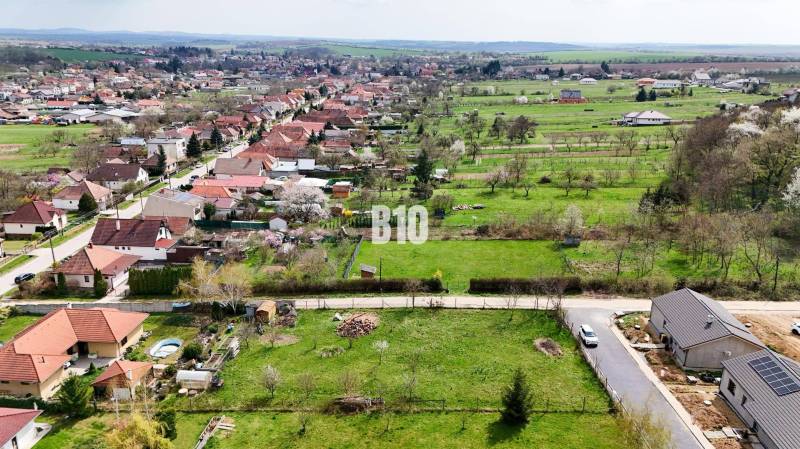 Jelenec  - Nádherný pozemok pri lese - 687 m2 - Letecký pohľad na obec Jelenec s rozsiahlou oblasťou vhodnou pre pozemky - bývanie.