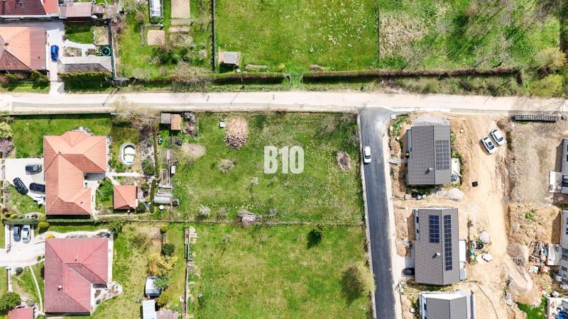 Jelenec  - Nádherný pozemok pri lese - 687 m2 - Letecký pohľad na pozemky - bývanie v Jelenci so susednými domami a zeleňou.