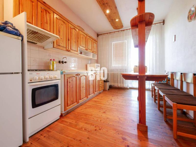 Rodinný dom s nádherným 8 árovým pozemkom na Kamennej ulici - Kuchyňa v rodinnom dome s dreveným dekorom a jedálenským kútom.