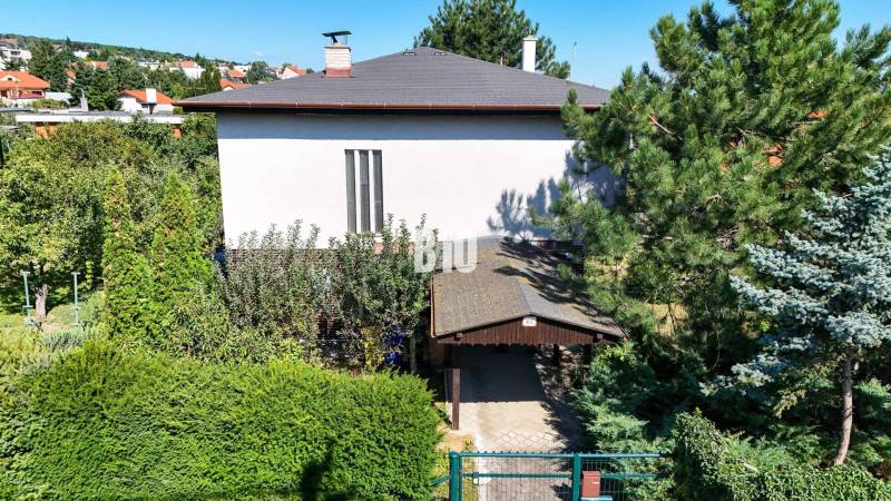 Rodinný dom s nádherným 8 árovým pozemkom na Kamennej ulici - Rodinný dom na Kamennej ulici v Nitre obklopený zeleňou a stromami.