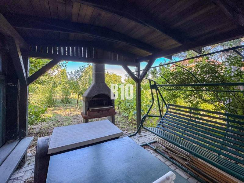 Rodinný dom s nádherným 8 árovým pozemkom na Kamennej ulici - Záhrada v Rodinnom dome na Kamennej ulici v Nitre so záhradným krbom a hojdačkou.