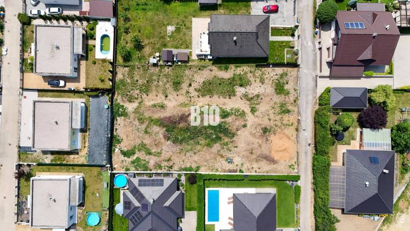 Štitáre - Pozemok so stavebným povolením -  805 m2 - Letecký pohľad na pozemky určené na bývanie v Štitároch, obklopené rodinnými domami.