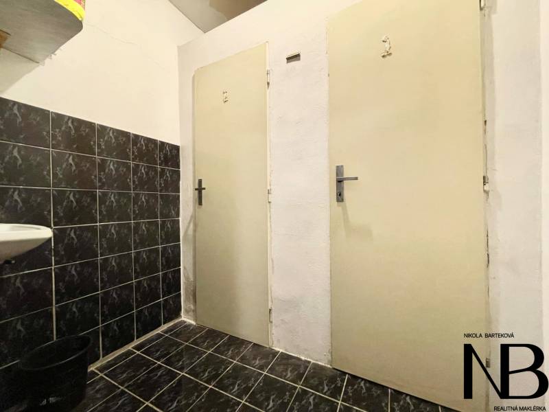 Na predaj rodinný dom s podnikateľským potenciálom, TN-Záblatie - Tmavá dlažba, biele steny a dvere v interiéri rodinného domu.