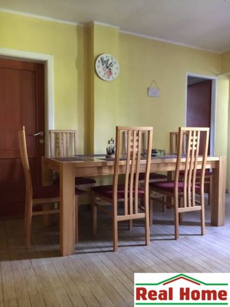 Dom s garážou na peknom rovinatom pozemku so šírkou 24m. - Jedáleň v rodinnom dome so stoličkami a stolom na podlahe s dreveným dekorom.